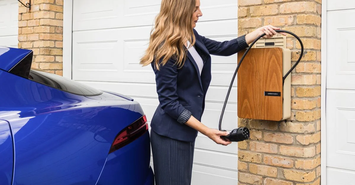 Une femme utilise une station de charge à domicile pour recharger sa voiture électrique, mettant en avant des choix de vie éco-responsables.