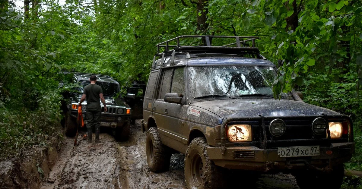 Aventure tout-terrain avec des SUVs circulant à travers des terrains forestiers boueux.
