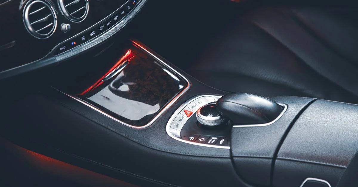 Gros plan sur un intérieur de voiture élégant mettant en avant des sièges en cuir et des commandes raffinées.
