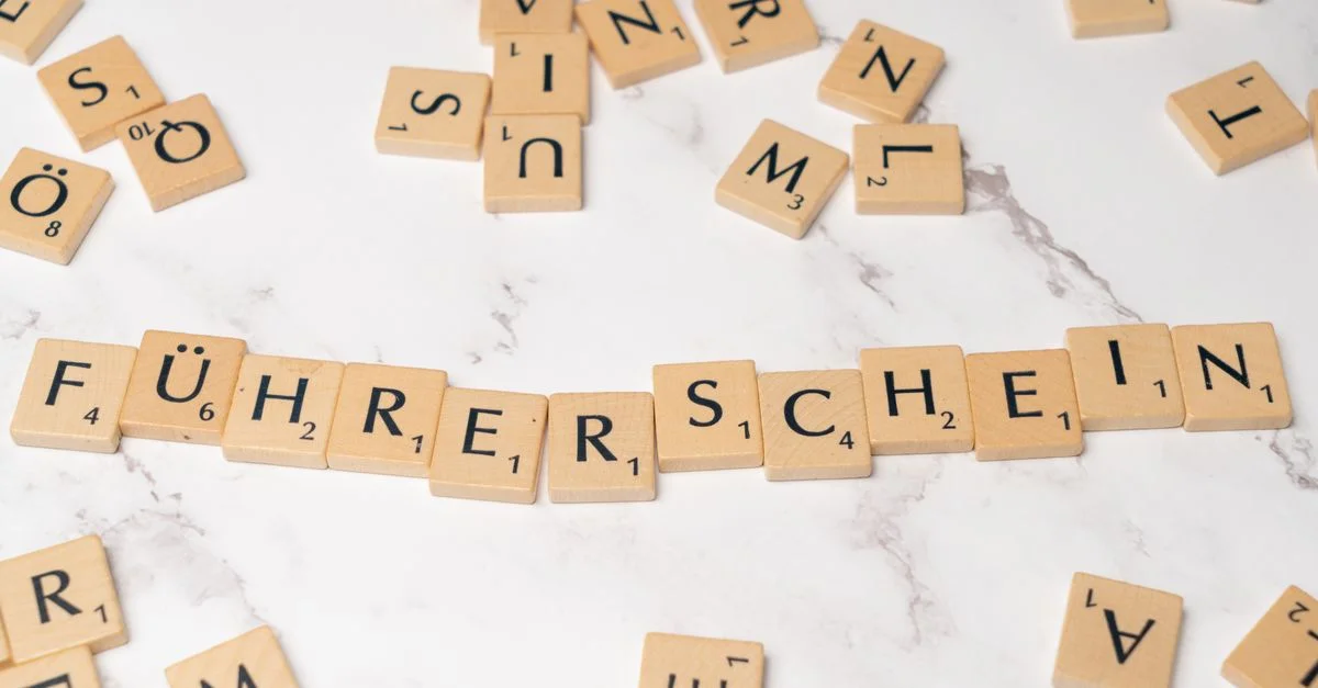 Des lettres de Scrabble disposées pour épeler 'Führerschein' sur une surface en marbre, représentant la langue et les jeux de mots.