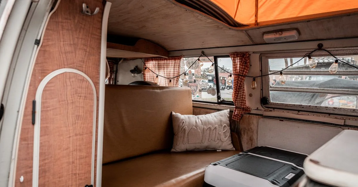 Un intérieur de camping-car vintage avec une décoration rétro et un éclairage chaleureux, parfait pour les amateurs de voyage.