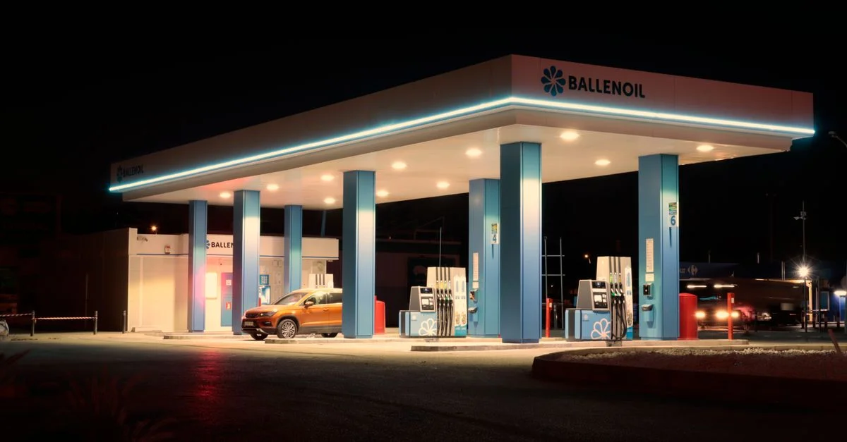 Station-service Ballenoil brillamment éclairée à Malaga, capturée la nuit avec un éclairage chaleureux.
