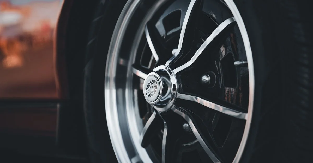 Vue détaillée d'une roue de voiture classique mettant en avant un jante chromé élégant et un design stylé.
