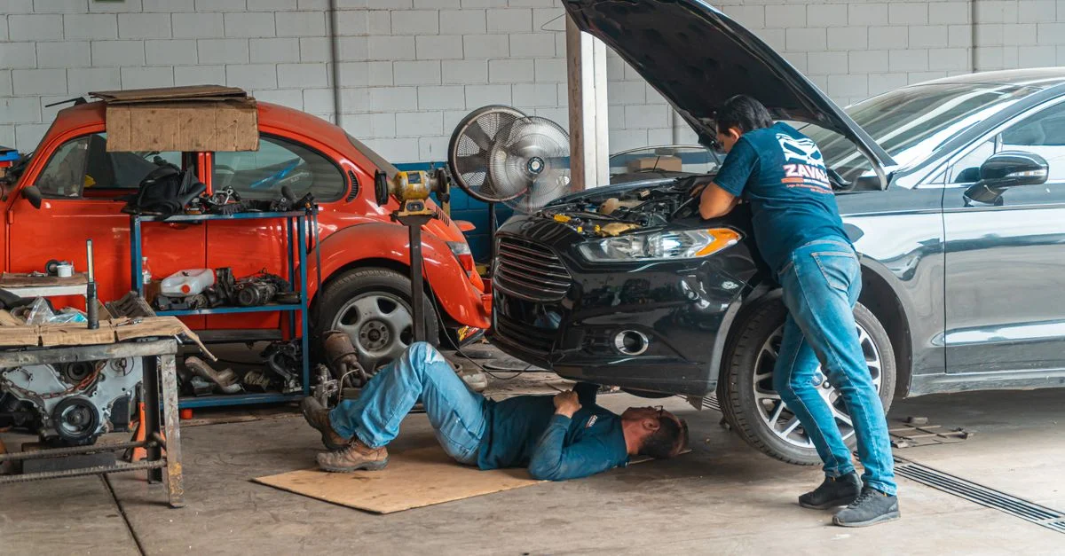 Mécaniciens travaillant dans un atelier automobile, réparant des voitures et effectuant l'entretien.