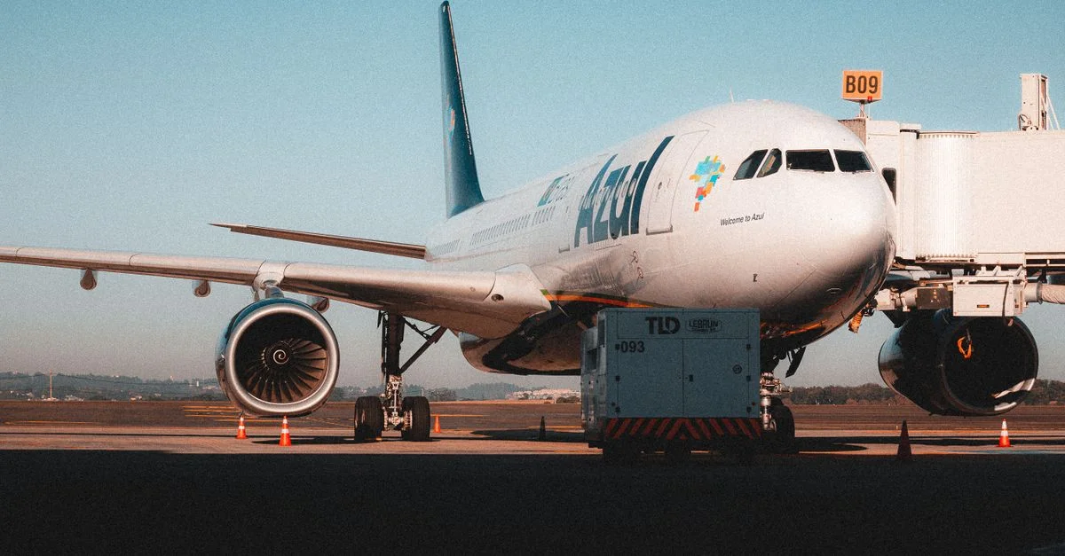 Avion de ligne attendant des passagers à la porte de l'aéroport sous un ciel dégagé.