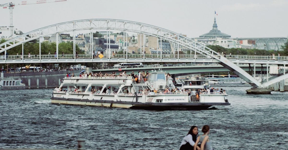 Bateau de tourisme naviguant sur la Seine près d'un pont à Paris, France.