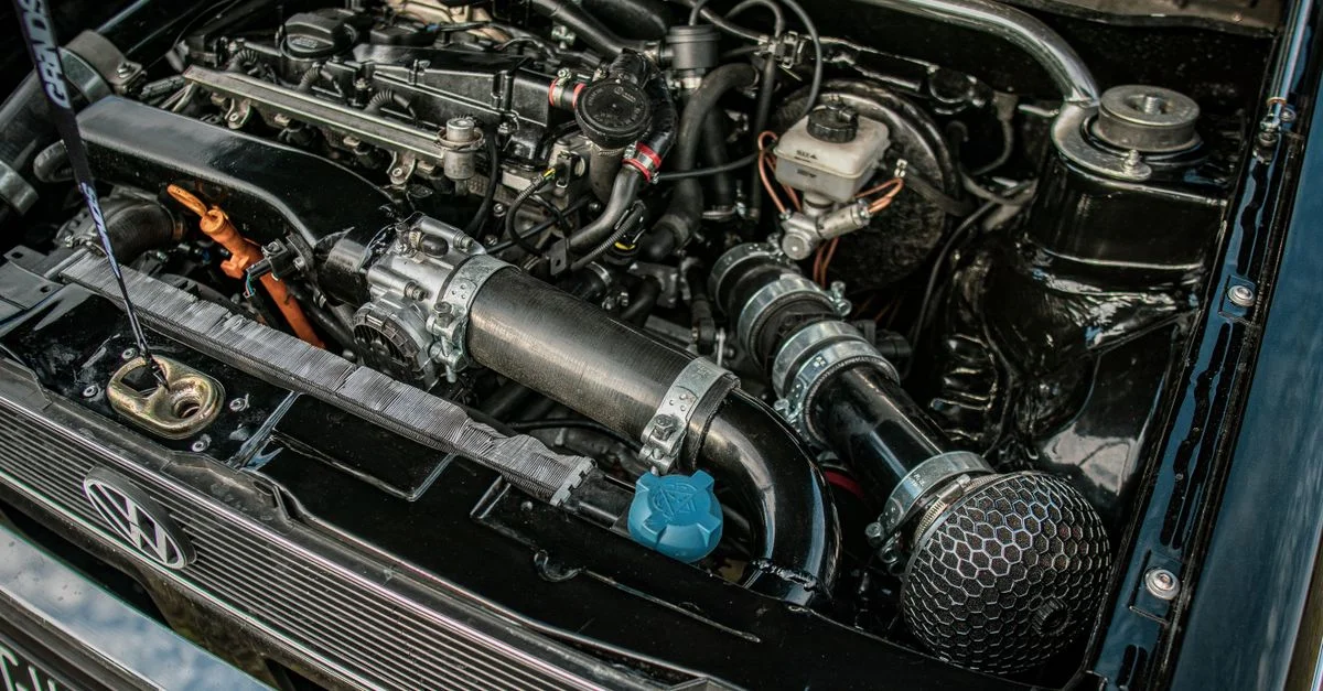 Gros plan d'un moteur de voiture haute performance sous un capot ouvert, mettant en avant les détails mécaniques et l'excellence en ingénierie.