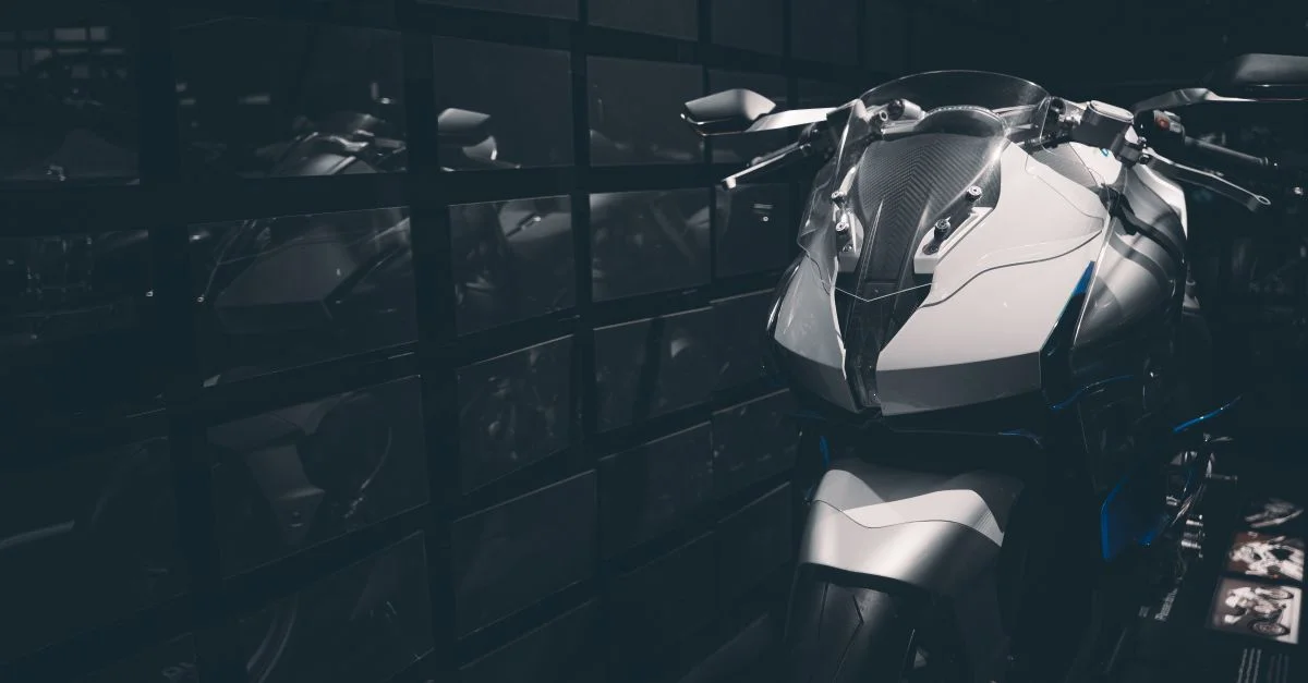 Moto de sport élégante présentée à l'intérieur avec des surfaces réfléchissantes, mettant en valeur un design moderne.