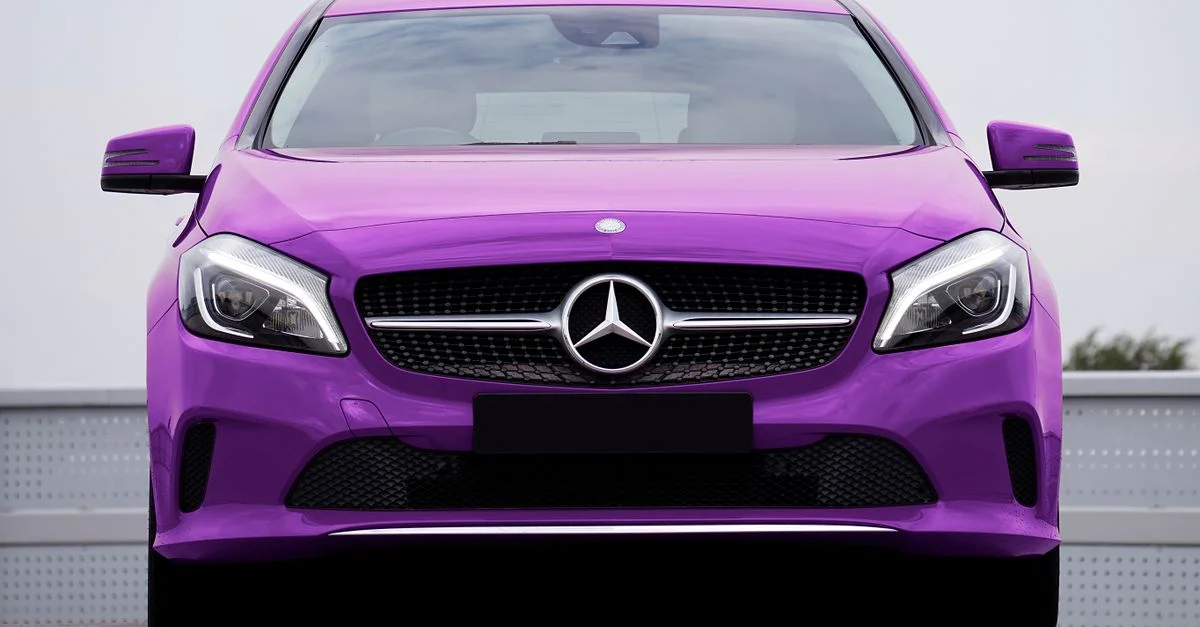 Image frappante d'une voiture de luxe violette avec un emblème prominent capturée dans un cadre urbain.
