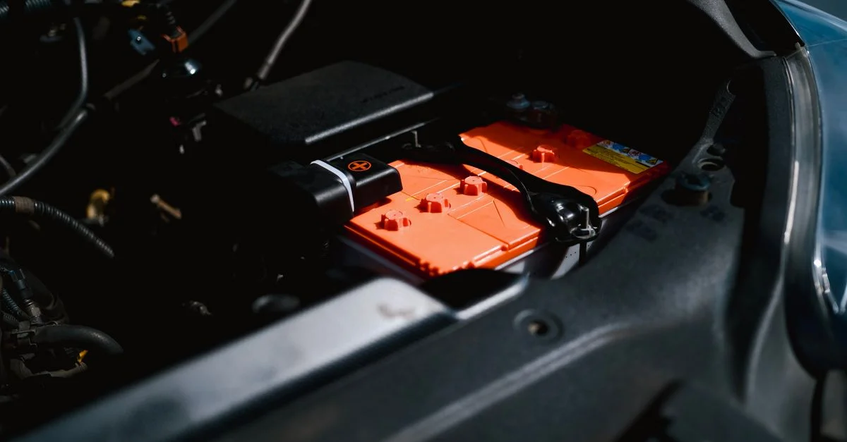 Vue détaillée d'une batterie de voiture électrique à l'intérieur du compartiment moteur d'un véhicule, mettant en évidence une technologie durable.