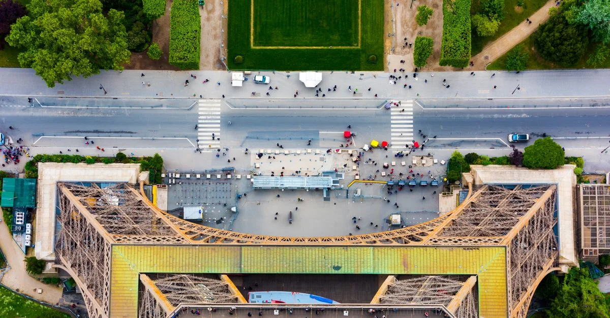 Une prise de vue aérienne vibrante capturant la vue de dessus de la Tour Eiffel et du paysage parisien environnant.