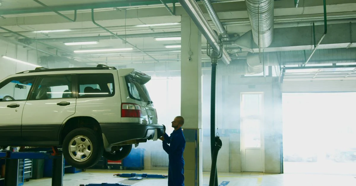 Mécanicien effectue l'inspection d'un véhicule dans un atelier automobile.