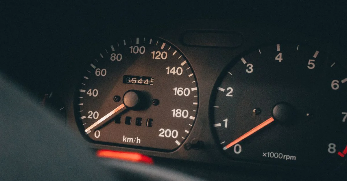 Vue détaillée du compteur de vitesse et du tachymètre d'une voiture affichant la vitesse et les tours par minute.