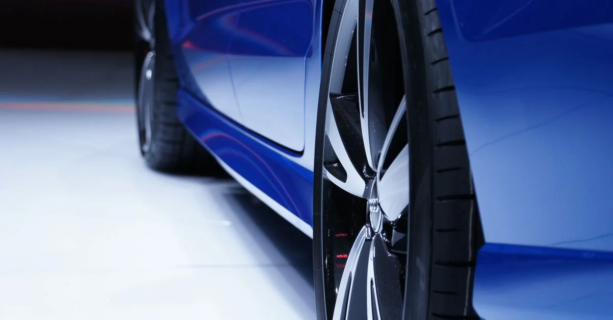 Gros plan d'une voiture bleue mettant en valeur la jante en alliage élégante. Parfait pour les passionnés d'automobile.