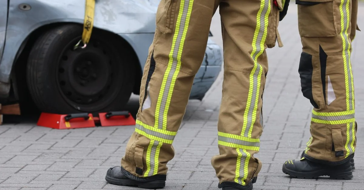 Des pompiers inspectent un accident de voiture avec un équipement de protection. Attention aux pantalons et aux chaussures.