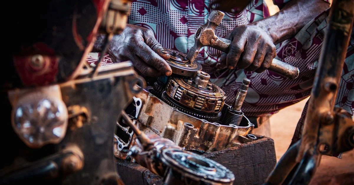 Mécanicien spécialisé dans l'assemblage de pièces de moteur de moto dans un atelier.