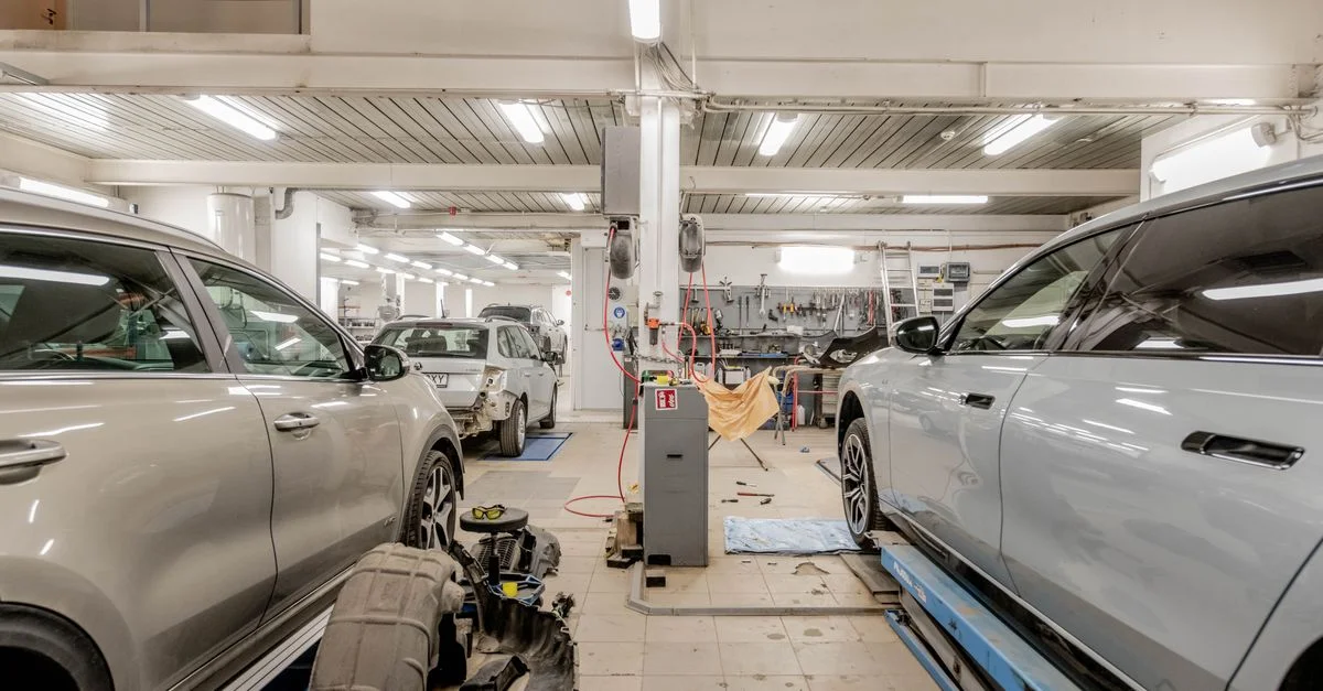 Intérieur d'un garage automobile avec des voitures en cours de maintenance et de service.