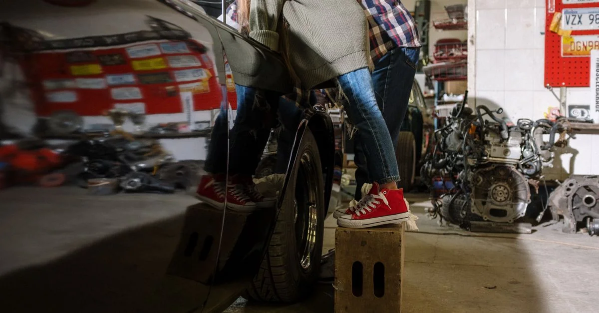 Un père et sa fille se retrouvent en travaillant sur une voiture dans un atelier de réparation, mettant en avant le travail d'équipe et la famille.
