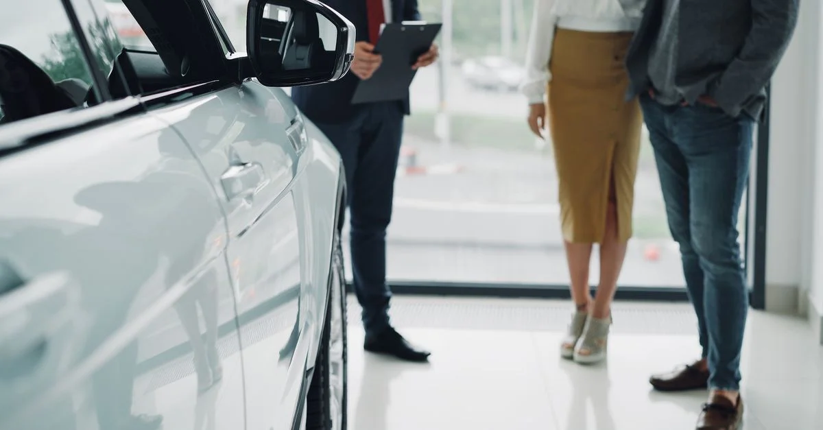 Consultation professionnelle chez un concessionnaire automobile avec des hommes d'affaires discutant des options de voiture.