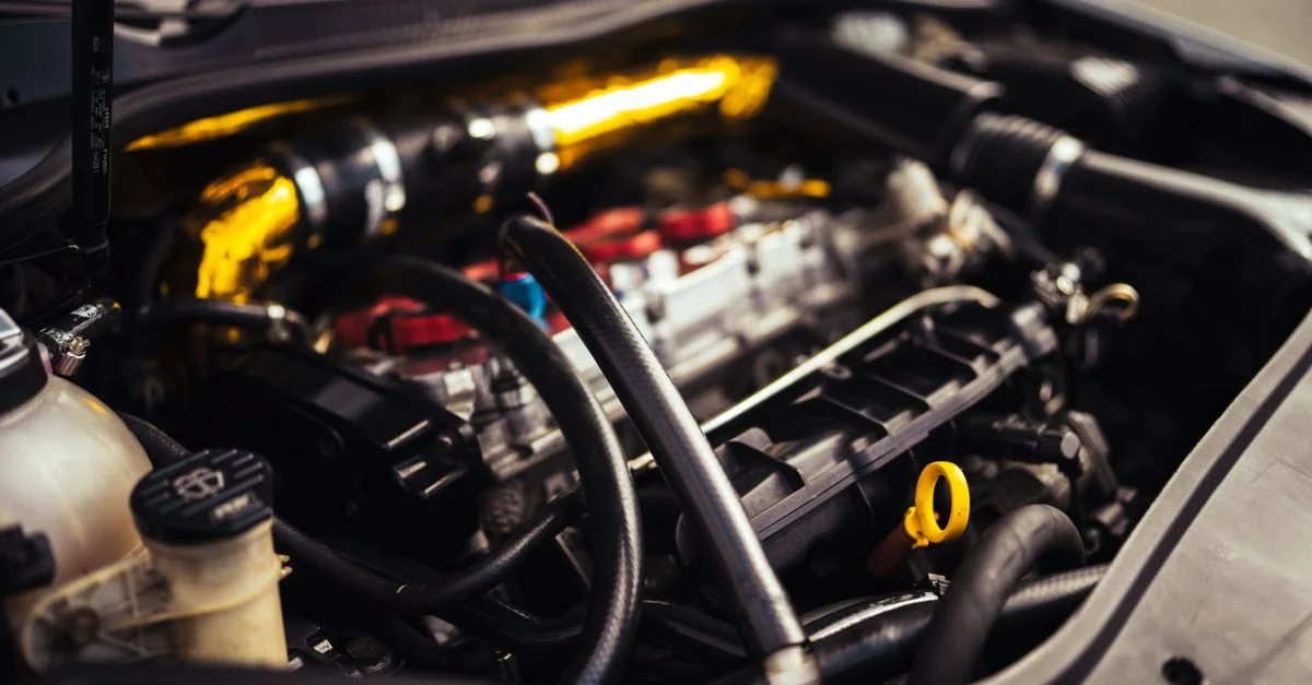 Image détaillée des composants du moteur de voiture mettant en valeur l'ingénierie automobile et la mécanique.